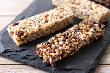  Tahta masada fındıklı, tohumlu ve siyah çikolatalı sağlıklı müsli çikolataları.