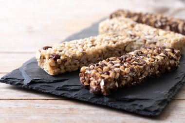  Tahta masada fındıklı, tohumlu ve siyah çikolatalı sağlıklı müsli çikolataları.