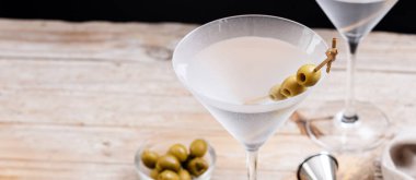 Votka martini kokteyli, votka, vermut ve ahşap masada yeşil zeytin. Panorama manzaralı. Boşluğu kopyala