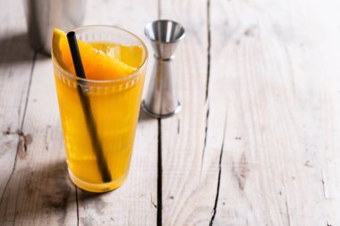 Tahta masada portakallı votka kokteyli. Boşluğu kopyala. Kokteyl tornavida.