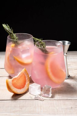 Tahta masada biberiyeyle süslenmiş greyfurt kokteyli.