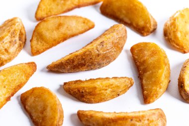 Beyaz arka planda izole edilmiş kızarmış patates parçaları.