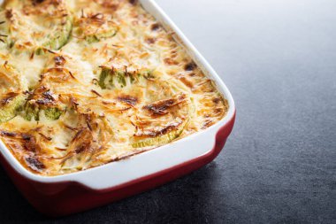 Siyah arka planda peynirli güveç ve graten kabağı. Boşluğu kopyala