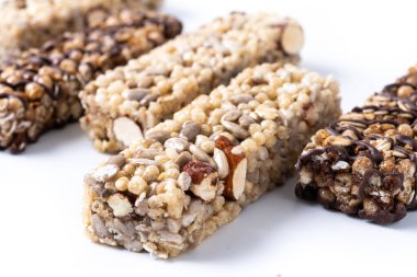 Beyaz arkaplanda fındık ve çekirdekli sağlıklı müsli çubuğu