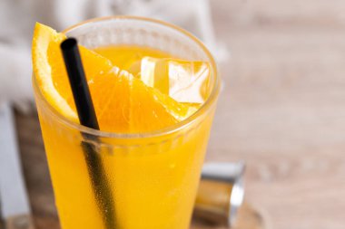 Ahşap masa ve siyah arka planda turuncu votka kokteyli. Boşluğu kopyala