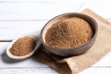 Hindistan cevizi palmiye şekeri, beyaz ahşap arka planda hindistan cevizi kasesi..