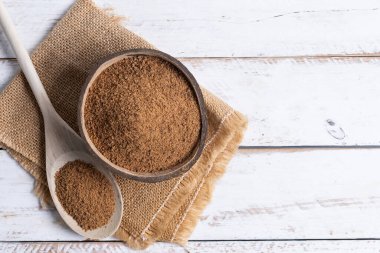 Hindistan cevizi palmiye şekeri ve hindistan cevizi kasesi beyaz ahşap masa arkasında. Üst manzara. Boşluğu kopyala