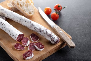 Fuet. Kurumuş sosis, siyah kayrak üzerinde.