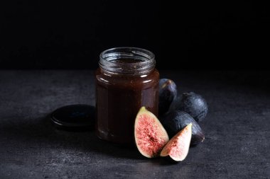 Tatlı reçel ve siyah arkaplanda taze incir.