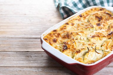 Ahşap masada peynirli güveç ve ızgara kabak. Boşluğu kopyala