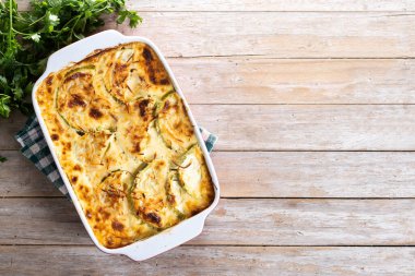 Ahşap masada peynirli güveç ve ızgara kabak. Üst Manzara. Boşluğu kopyala