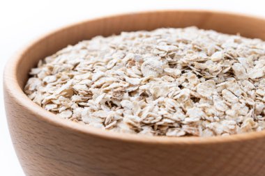 Yuvarlanmış yulaf, beyaz arka planda izole edilmiş kasede sağlıklı kahvaltı gevreği. Kapat.