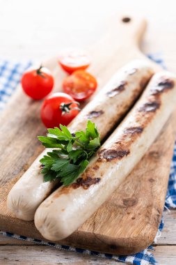 Ahşap masada domatesli ızgara sucuklu sosis.