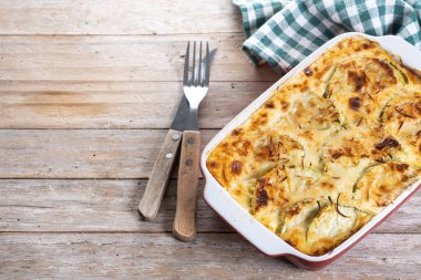 Ahşap masada peynirli güveç ve ızgara kabak. Boşluğu kopyala