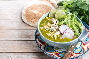 Geleneksel Meksika yeşil pozole çorbası ahşap masada. Boşluğu kopyala