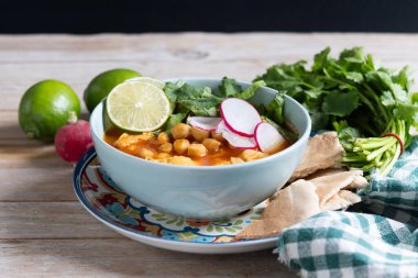 Geleneksel Meksika kırmızı pozole çorbası ahşap masada.