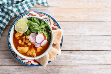 Traditional mexican red pozole soup on wooden table. Top view. Copy space clipart