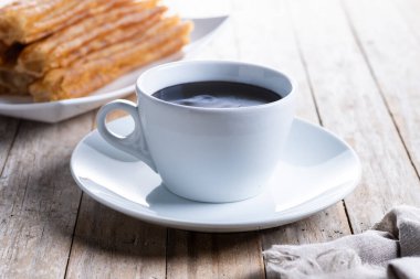 Ahşap masada churros soslu sıcak çikolata. Geleneksel İspanyol yemekleri