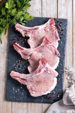 Tahta masada taze domuz pirzolası. Üst görünüm