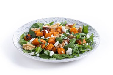 Beyaz arka planda roka, ceviz ve beyaz peynirli kabak salatası.