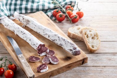 Fuet. Ahşap masada kurutulmuş sosis.