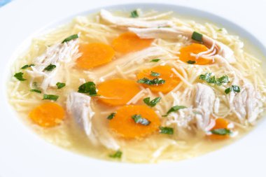 Mavi arka planda ev yapımı tavuk çorbası. Kapat.