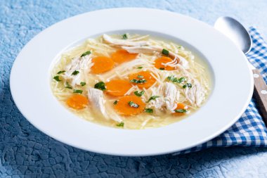 Mavi arka planda ev yapımı tavuk çorbası.