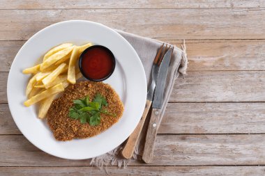 Cachopo, Traditional food in Asturias, Spain. Breaded fillet meat on wooden table. Top view. Copy space clipart