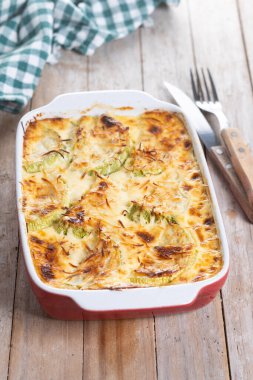 Peynirli güveç ve ahşap masada graten kabağı.