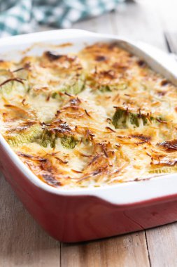 Peynirli güveç ve ahşap masada graten kabağı.