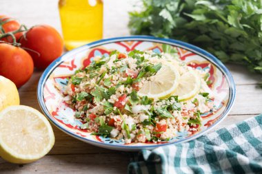 Tahta masa üzerinde kuskus olan Tabbouleh salatası. Geleneksel Lübnan yemekleri