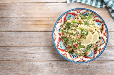 Tahta masa üzerinde kuskus olan Tabbouleh salatası. Geleneksel Lübnan yemekleri. Üst Manzara. Boşluğu kopyala