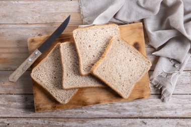 Ahşap masada sağlıklı ekmek dilimleri var. Üst görünüm