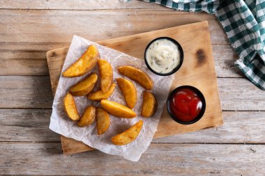 Beyaz arka planda izole edilmiş soslu kızarmış patates dilimleri. Üst görünüm