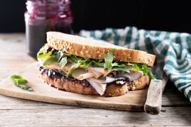 Tahta masada Şükran Günü için kızılcık soslu hindili sandviç.