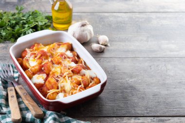 Domates soslu Gnocchi Alla Sorrentina ve ahşap masada fırında eritilmiş mozzarella peyniri. Boşluğu kopyala