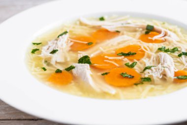 Ahşap masada ev yapımı tavuk çorbası.