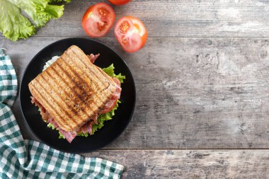 Bacon sandwich with lettuce and tomato on wooden table.Top view. Copy space clipart