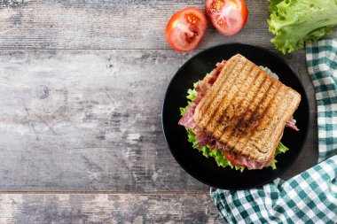 Marullu pastırmalı sandviç ve ahşap masa. Üst manzara. Boşluğu kopyala