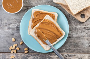 Tahta masada fıstık ezmesi kremalı ekmek tostu. Üst görünüm