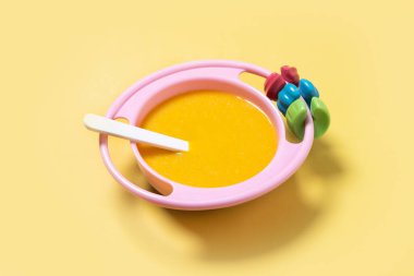 Bebek mamasıyla bovling. Sarı arka planda sebze püresi