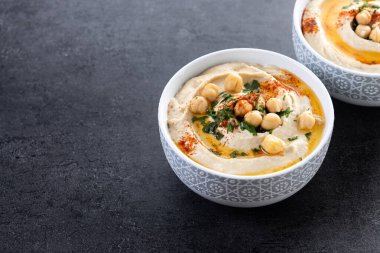 Siyah arka planda zeytinyağı, maydanoz ve kırmızı biberli nohut. Boşluğu kopyala