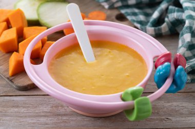 Bebek mamasıyla bovling. Tahta masada sebze püresi