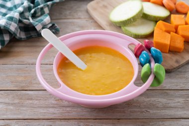 Bebek mamasıyla bovling. Tahta masada sebze püresi