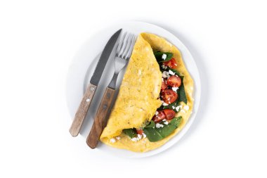 Beyaz arka planda domatesli ve ıspanaklı omlet.