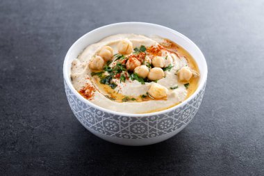 Siyah arka planda zeytinyağı, maydanoz ve kırmızı biberli nohut.