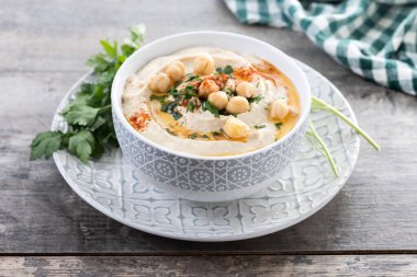 Ahşap masada zeytinyağı, maydanoz ve kırmızı biberli nohut.