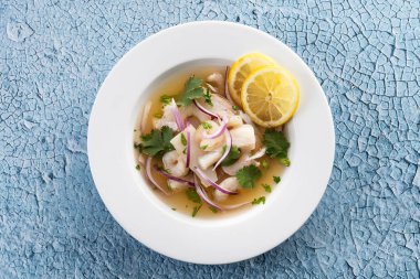 Geleneksel Peru ceviche deniz levreği filetosu mavi arka planda