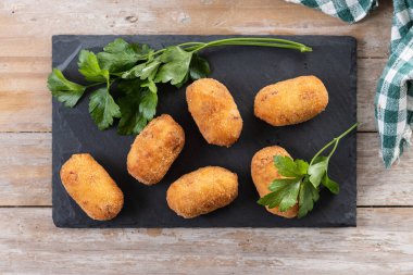 Tahta masada kızarmış morina kroketleri. Üst görünüm