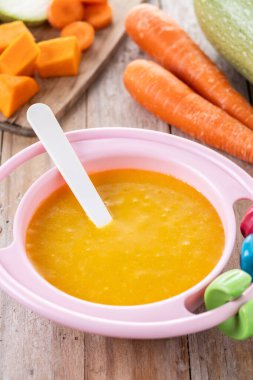 Bebek mamasıyla bovling. Tahta masada sebze püresi